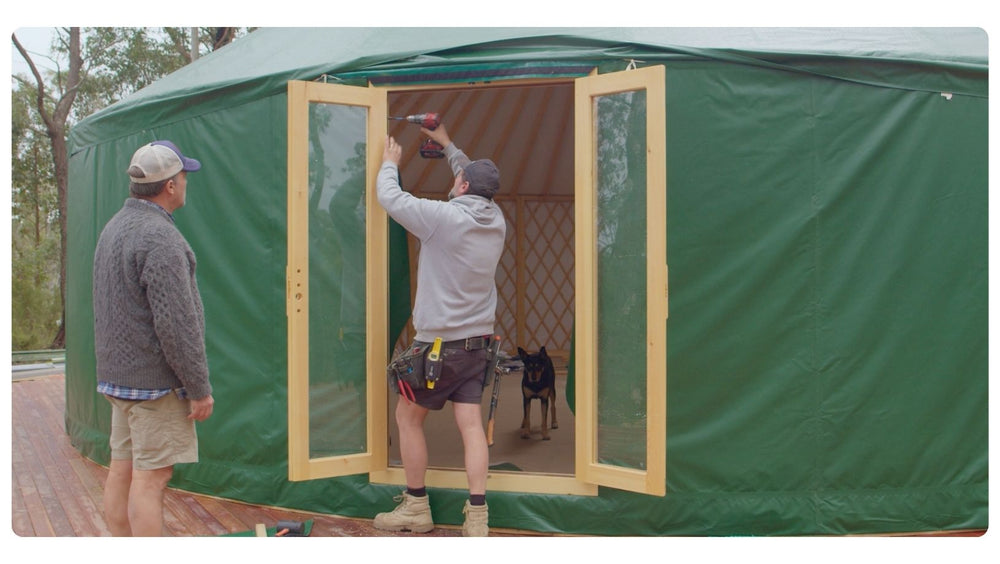 Double Glass Door being installed on a green yurt, creating an extra entry point from the circular space to the outdoors.