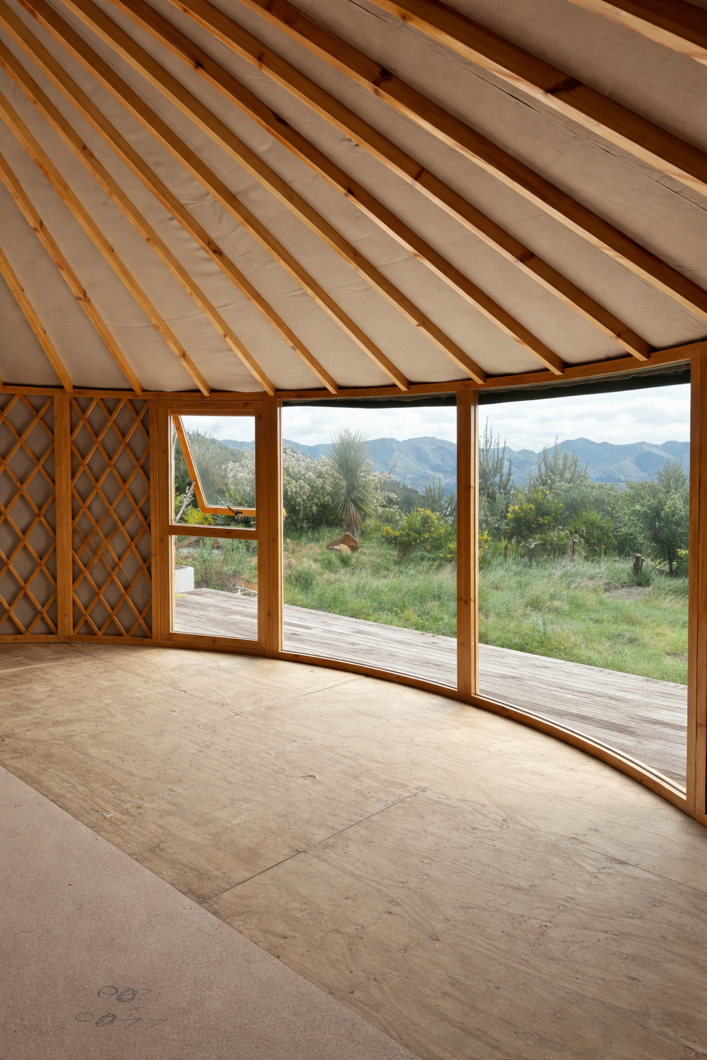 Yurt interior with floor-to-ceiling windows and timber frame, positioned to capture natural views and maximise light and connection to the landscape