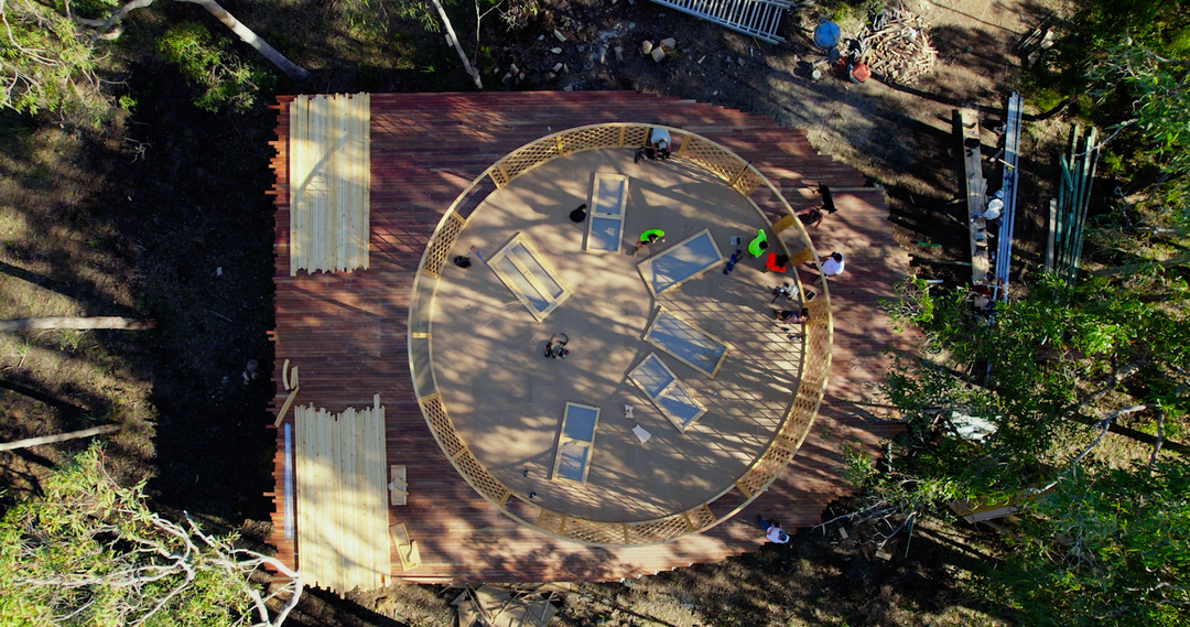 Drone shot of yurt walls being installed on wooden deck