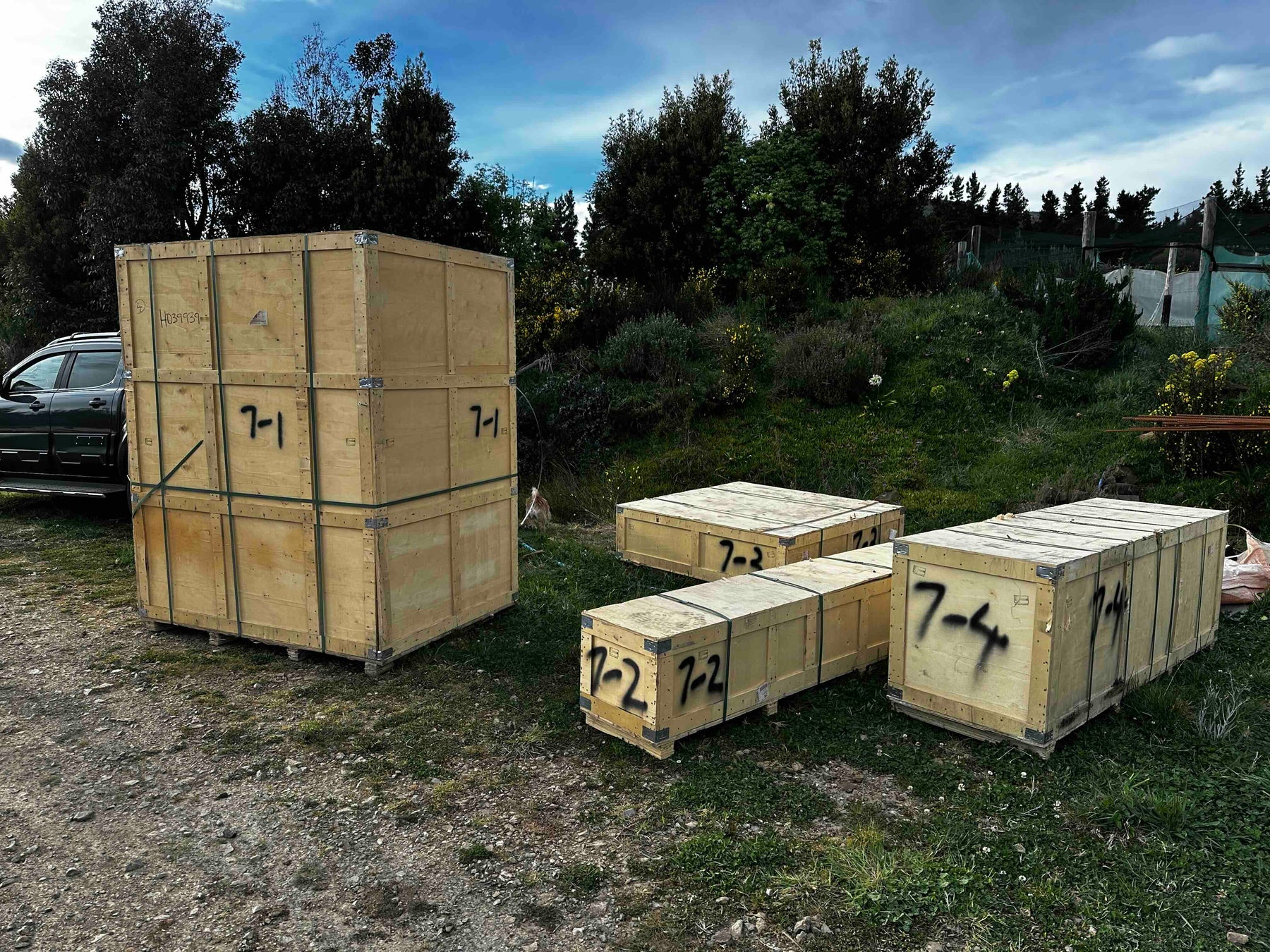Numbered Beyond Yurt modular kit crates on site, labelled by yurt size and crate sequence for assembly.