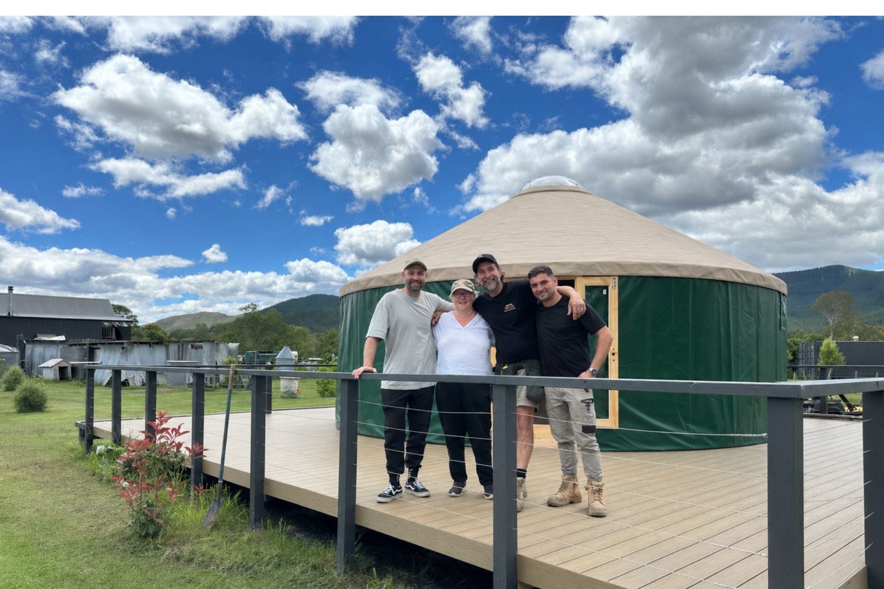 Yurt connected to a deck beside a home with people standing outside, showing seamless extension of space