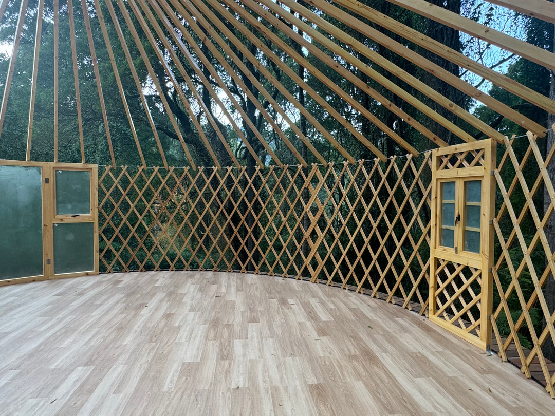 8 metre wooden yurt with lattice walls and doors, surrounded by trees