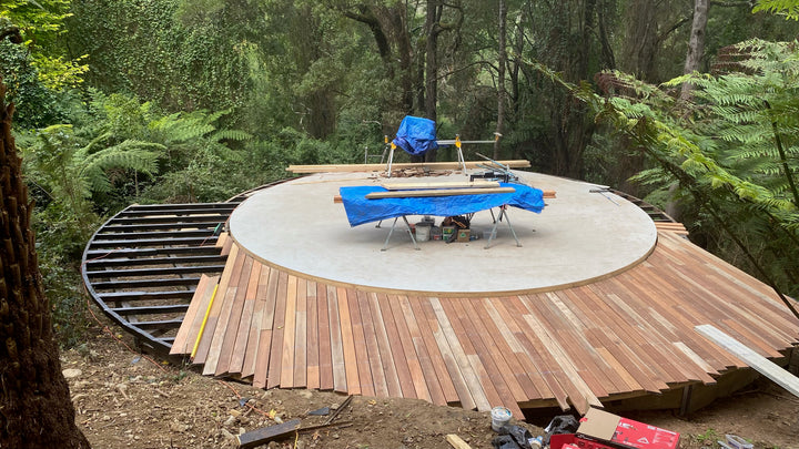 Wooden yurt platform with a circular base in a forest setting