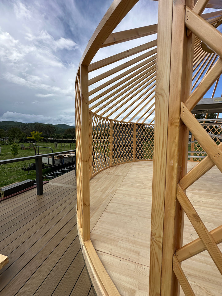 Yurt wooden deck with lattice walls and blue sky reflection
