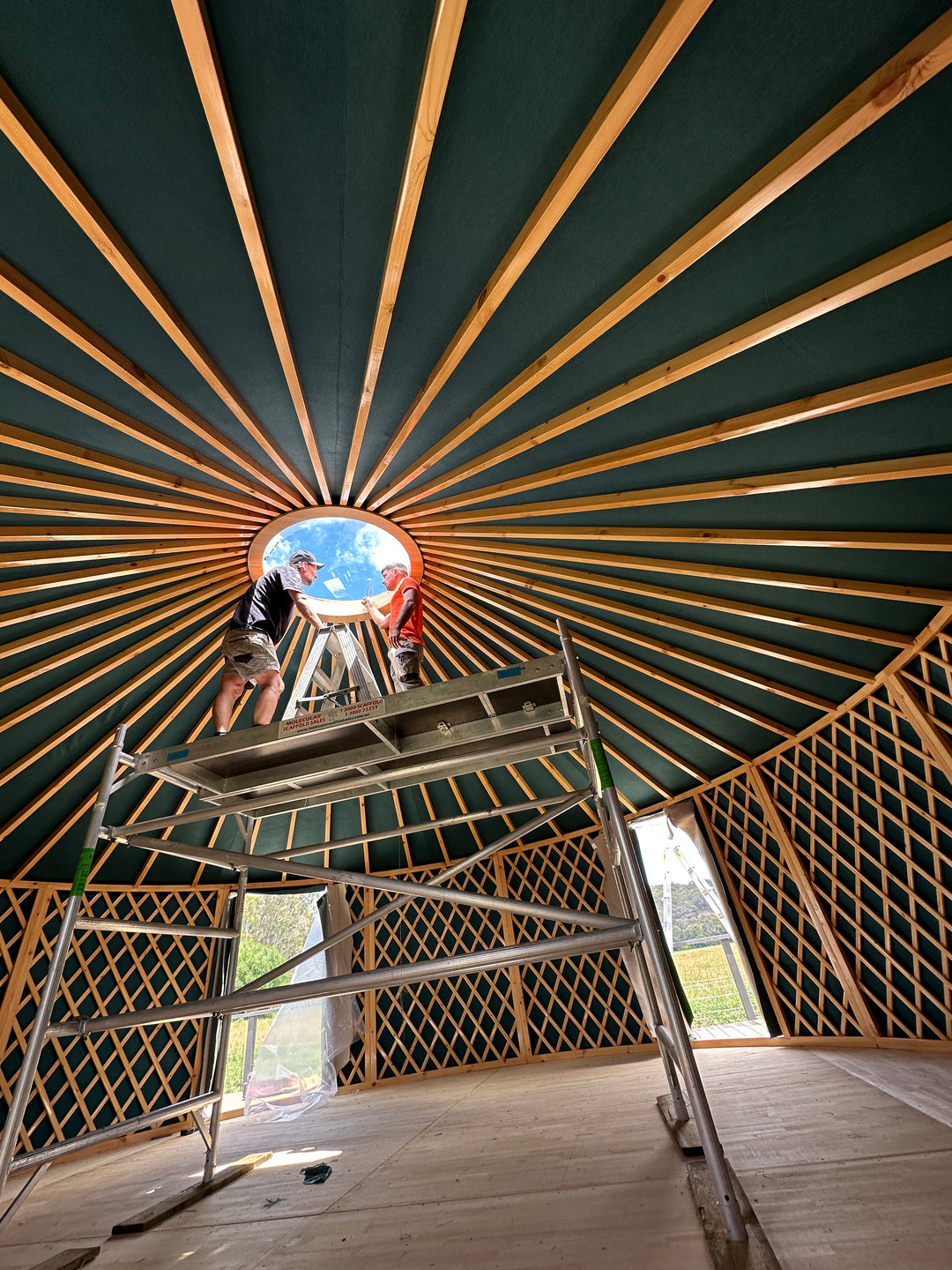 Scaffolding inside wooden yurt during installation